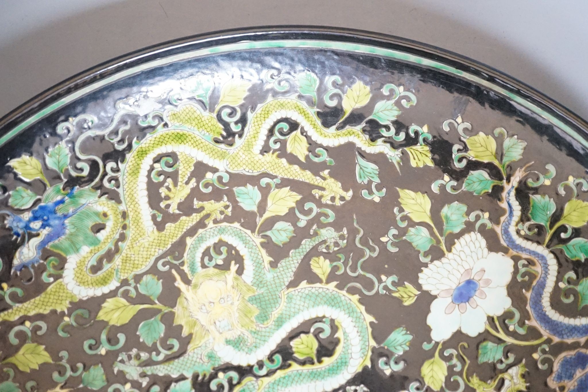 A large Chinese black ground 'dragon' dish, 43cm